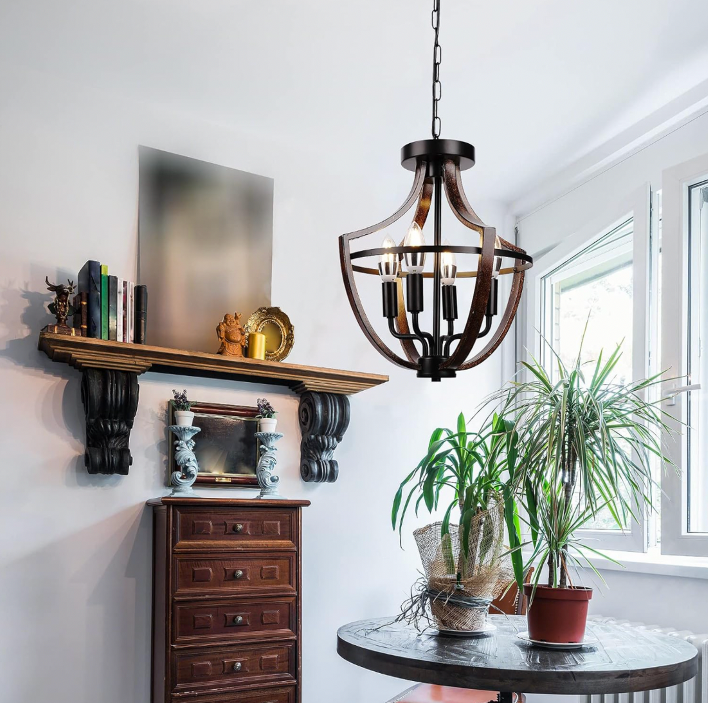 Lustre cage à 4 lumières en métal noir et effet bois foncé suspendu à une chaîne dans un coin de salon avec étagère manteau rustique et plantes en pot