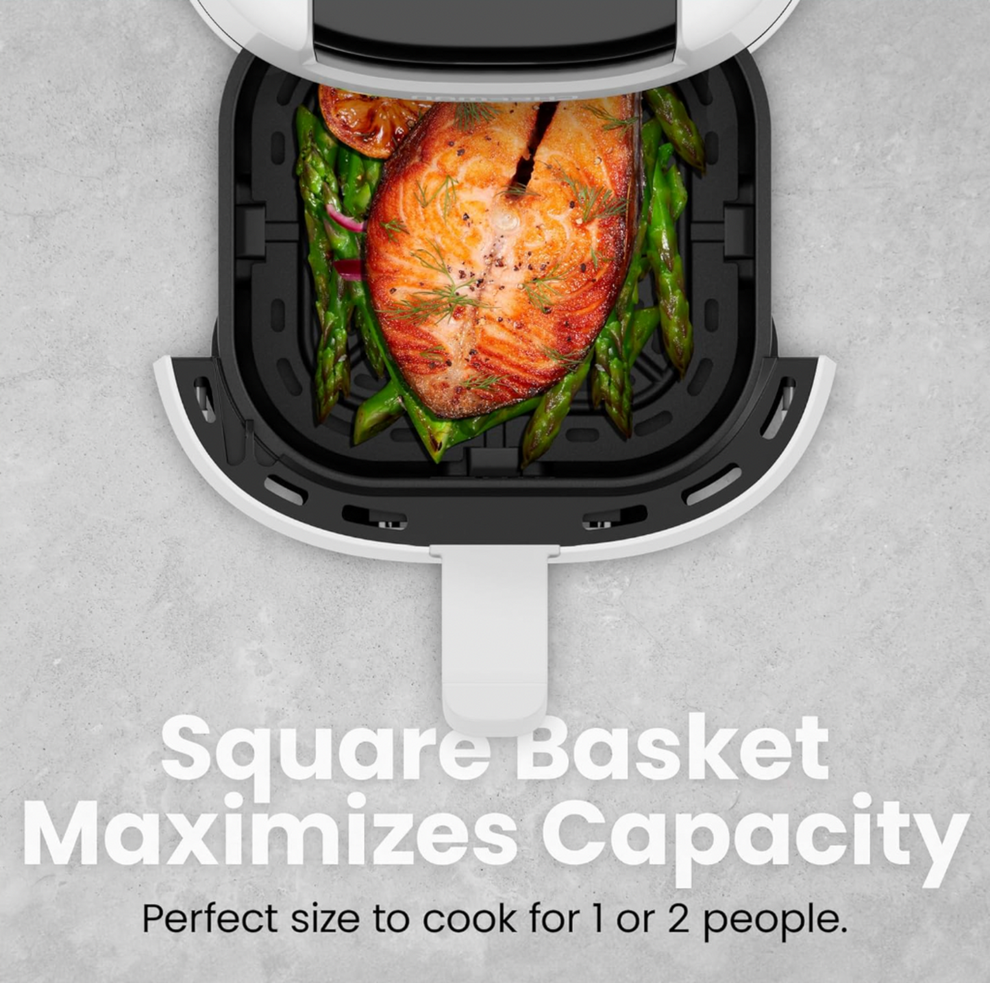 Vue plongeante de la friteuse à air blanche avec panier carré sorti montrant filet de saumon sur lit d'asperges, mention Square Basket Maximizes Capacity