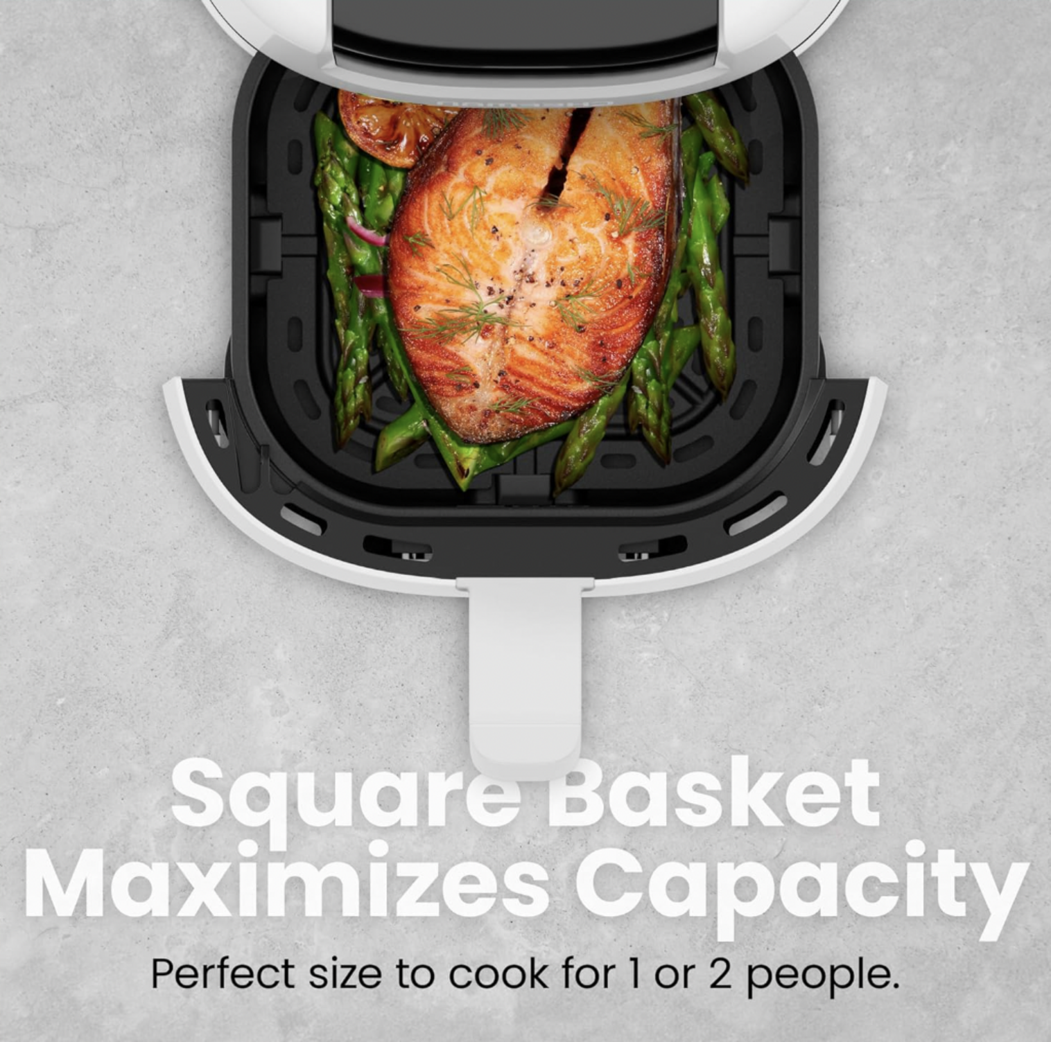 Vue plongeante de la friteuse à air blanche avec panier carré sorti montrant filet de saumon sur lit d'asperges, mention Square Basket Maximizes Capacity