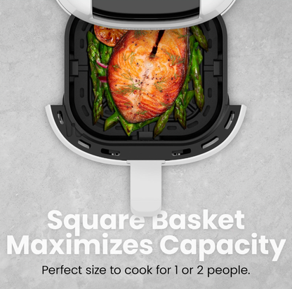 Vue plongeante de la friteuse à air blanche avec panier carré sorti montrant filet de saumon sur lit d'asperges, mention Square Basket Maximizes Capacity