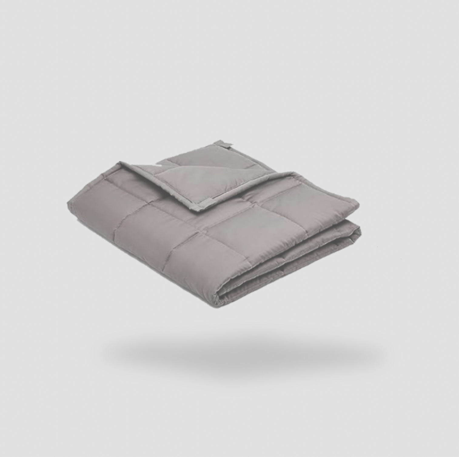 Couverture lestée grise pliée sur fond blanc, vue produit en perspective