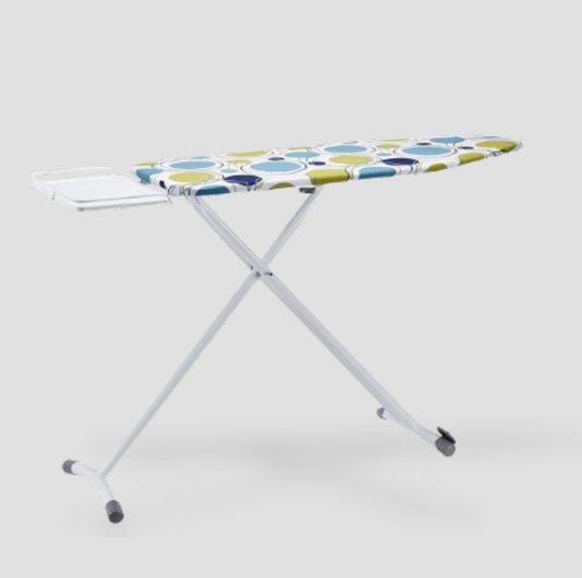 White ironing board with blue and green circles print cover, integrated iron rest and X-frame legs, three-quarter view