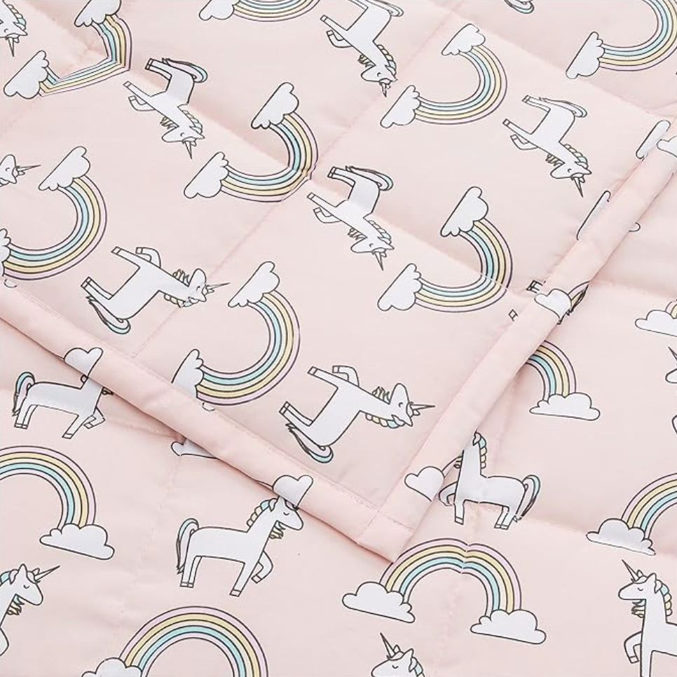 Pink kids weighted blanket pattern detail with unicorns and rainbows on cotton fabric