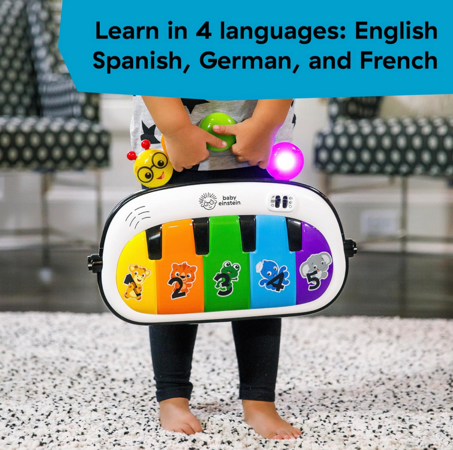 Enfant debout derrière le panneau piano multicolore Baby Einstein avec touches numérotées et illustrations d'animaux, mention Learn in 4 languages English Spanish German French