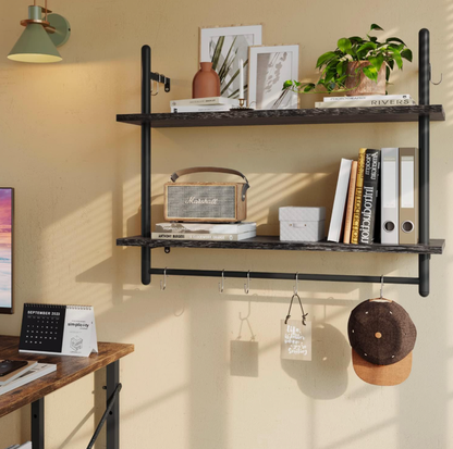 Étagère flottante industrielle 31 pouces Bestier noire à deux étages avec barre et crochets supportant haut-parleur, livres et plante dans un bureau à domicile