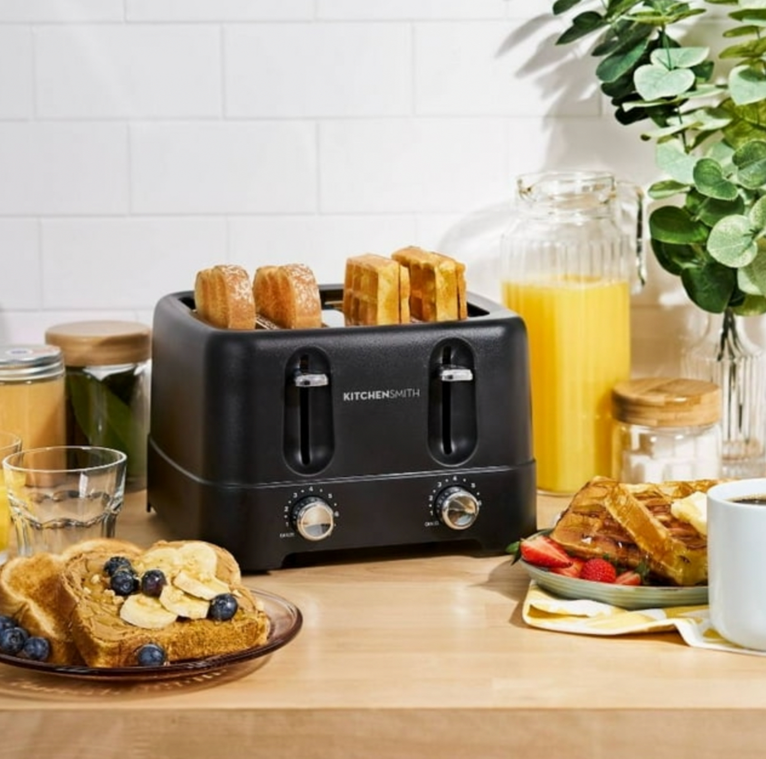 Grille-pain noir 4 tranches sur comptoir en bois avec rôties, jus et eucalyptus, scène petit-déjeuner