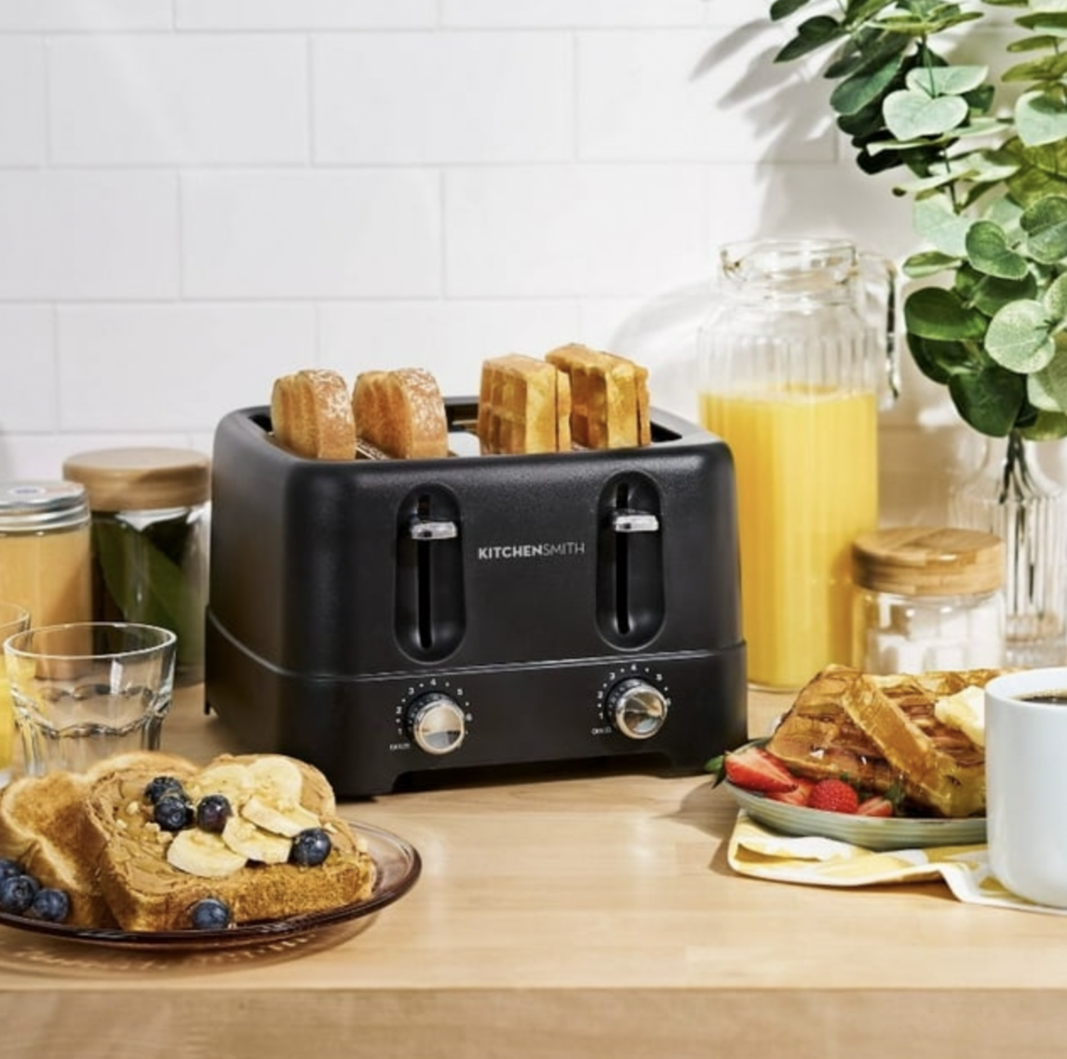 Grille-pain noir 4 tranches sur comptoir en bois avec rôties, jus et eucalyptus, scène petit-déjeuner