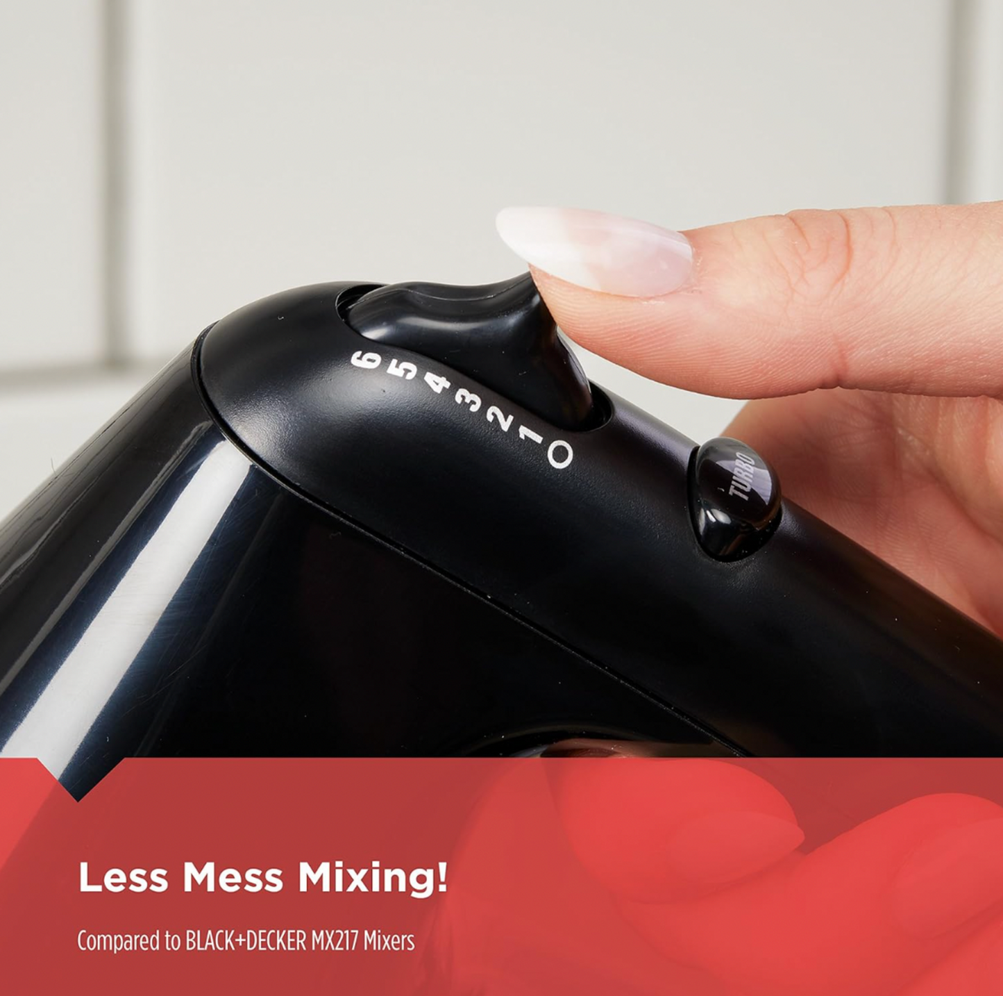 Close-up of finger pressing speed selector on black hand mixer showing numbers 0 to 6 with Less Mess Mixing callout