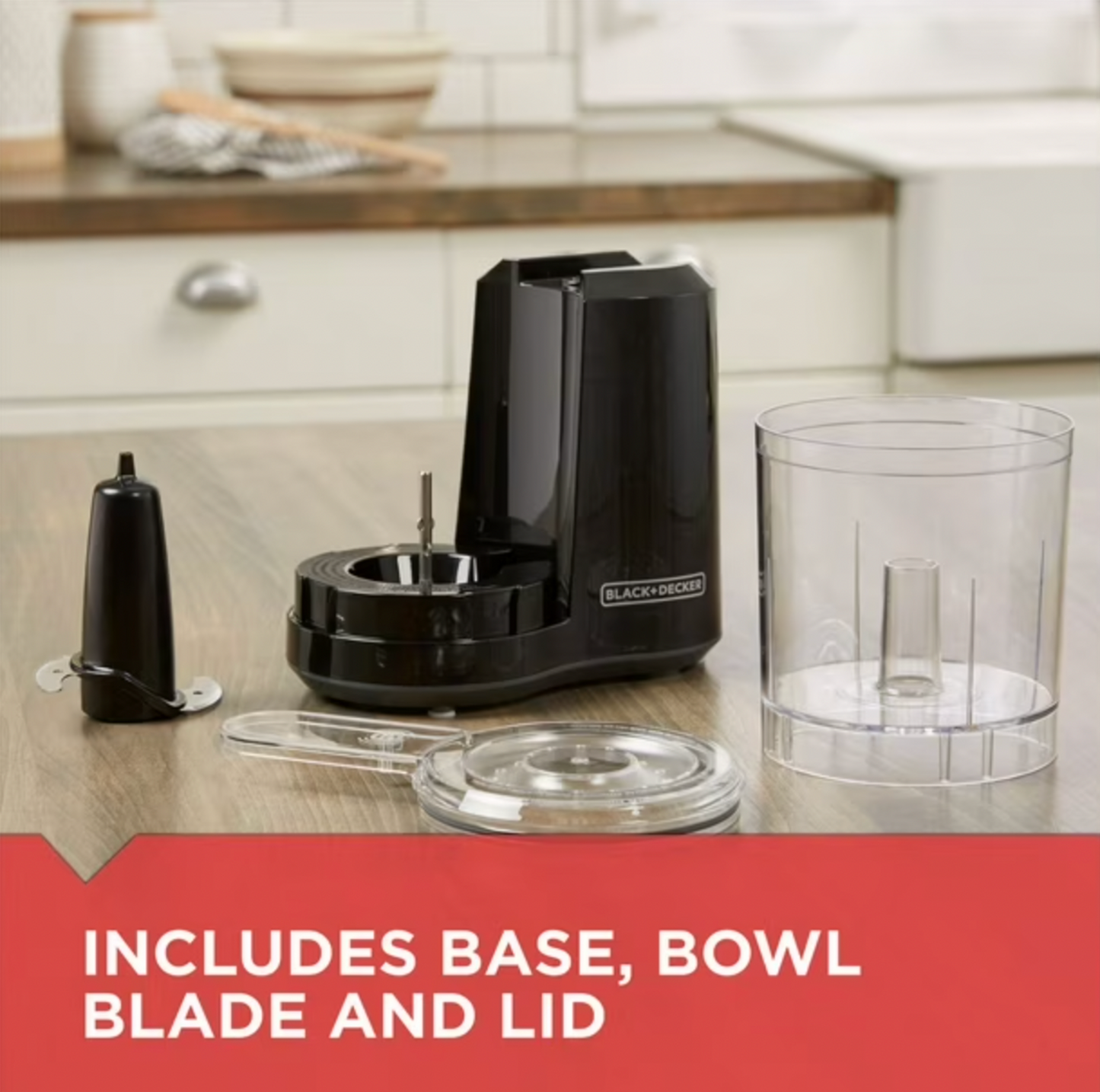 Mini robot culinaire BLACK+DECKER noir démonté sur comptoir en bois montrant base, bol transparent, couvercle et lame, mention Includes Base Bowl Blade and Lid
