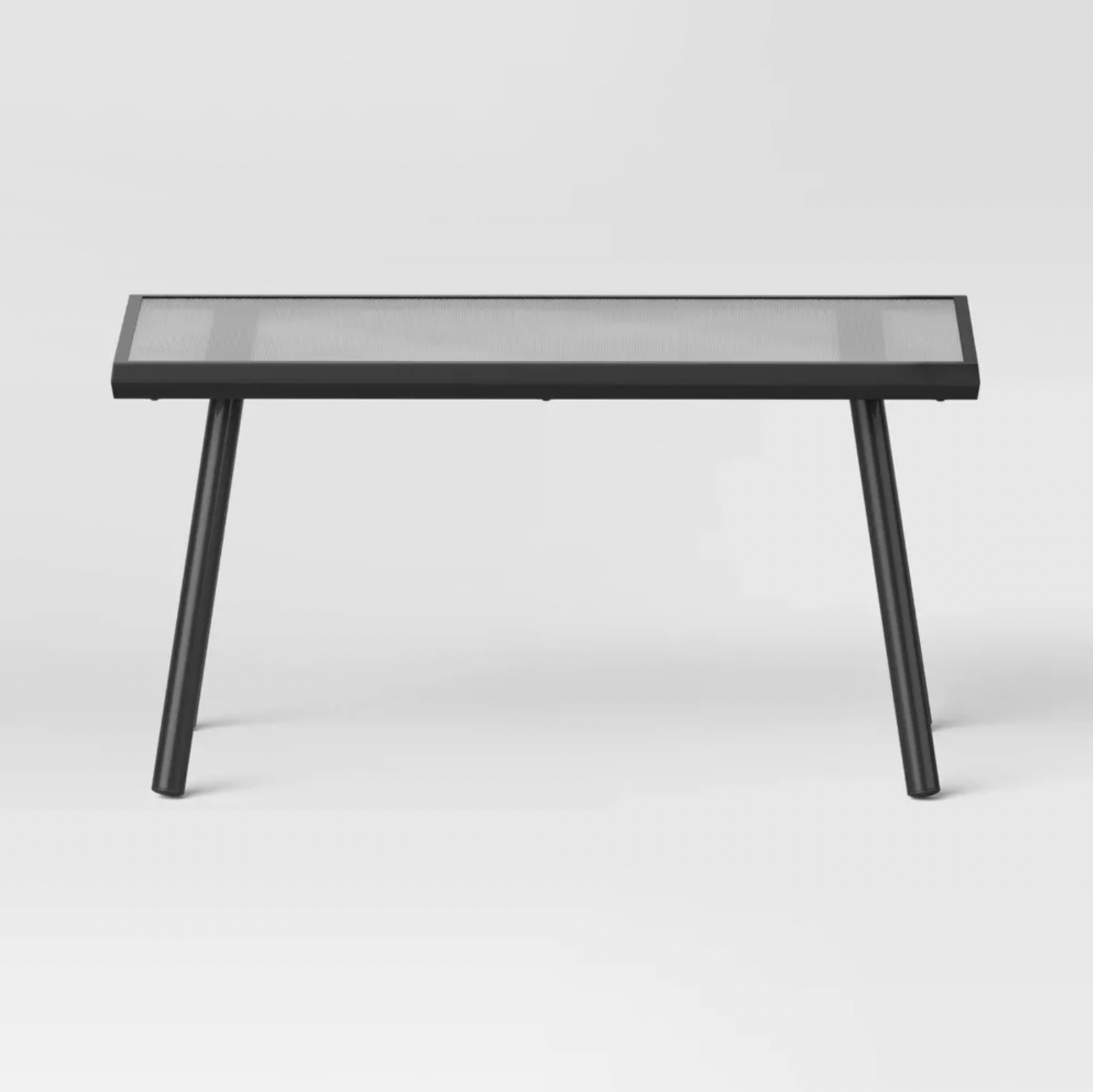 Vue de face de la table basse rectangulaire en acier noir avec plateau en verre texturé et pieds évasés