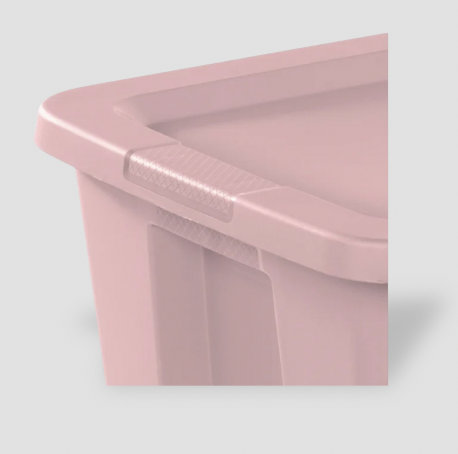 Gros plan d'un coin du couvercle rose pâle montrant le détail texturé du fermoir