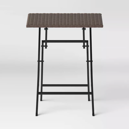 Vue de face de la table d'appoint pliante à plateau en osier brun avec piètement en X en métal noir