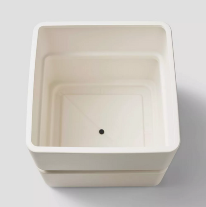 Vue de dessus du cache-pot carré en céramique crème vide montrant les parois intérieures et le trou de drainage