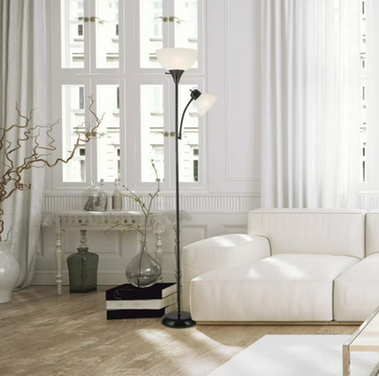 Lampadaire torchère Delilah noir éclairant un salon de style parisien avec canapé blanc et console