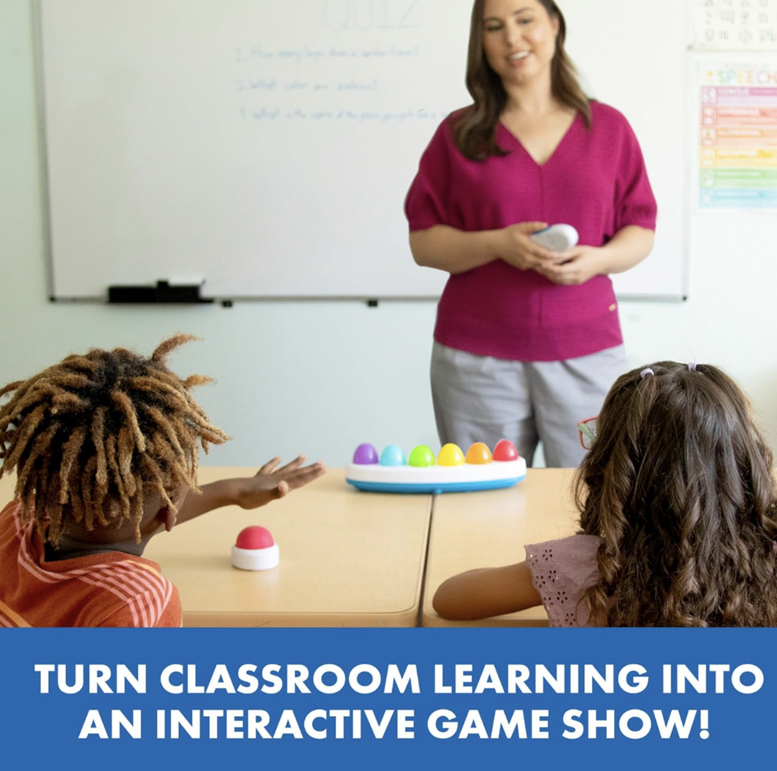 Enseignante en chemise rose tenant un buzzer Eggspert dans une salle de classe avec deux élèves assis au bureau avec la base de buzzer arc-en-ciel, mention Turn Classroom Learning Into an Interactive Game Show