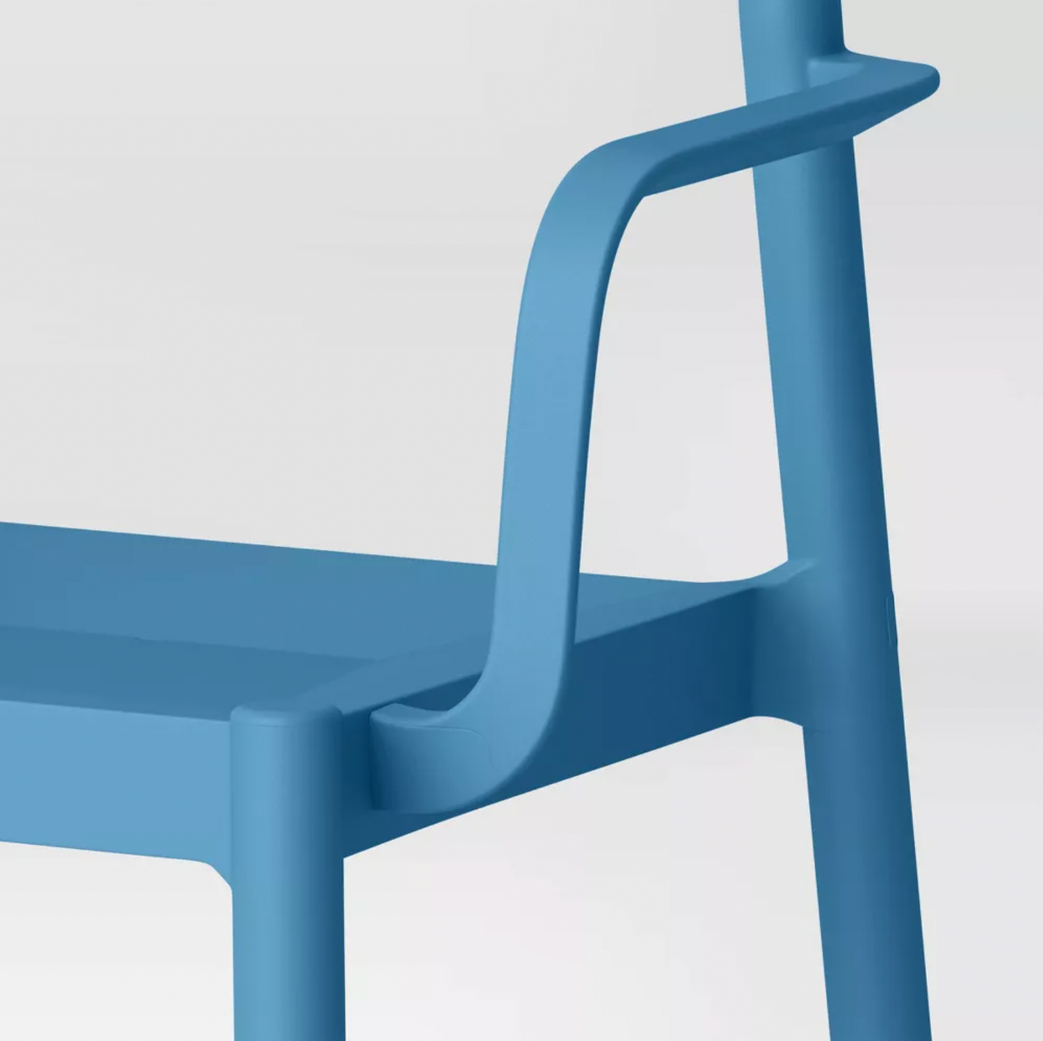 Gros plan de l'accoudoir bleu de la chaise de patio Elba reliant le siège incurvé et le support de dossier