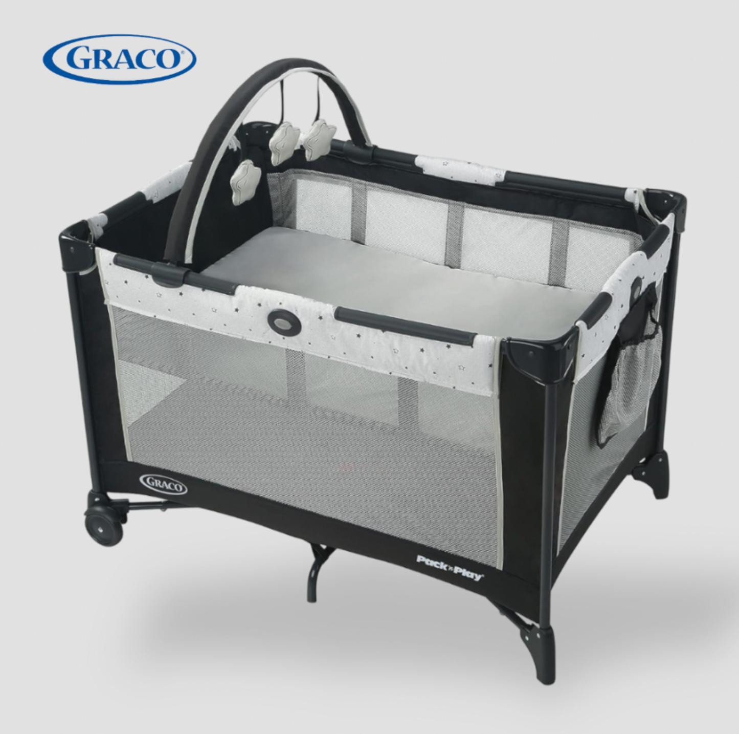 Parc Graco Pack n Play On the Go gris et noir avec bassinette, arche à jouets et peluches, vue trois-quarts