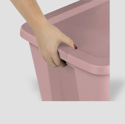 Main saisissant la poignée moulée latérale d'une boîte de rangement en plastique rose pâle