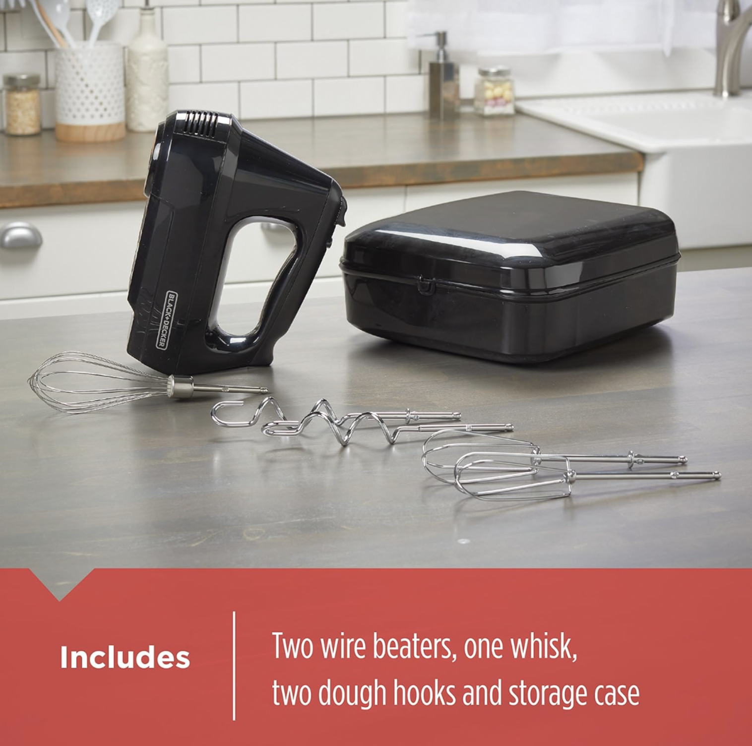 Black BLACK+DECKER hand mixer on kitchen counter beside storage case with included whisk, wire beaters and dough hooks