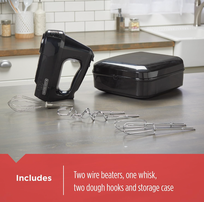 Black BLACK+DECKER hand mixer on kitchen counter beside storage case with included whisk, wire beaters and dough hooks