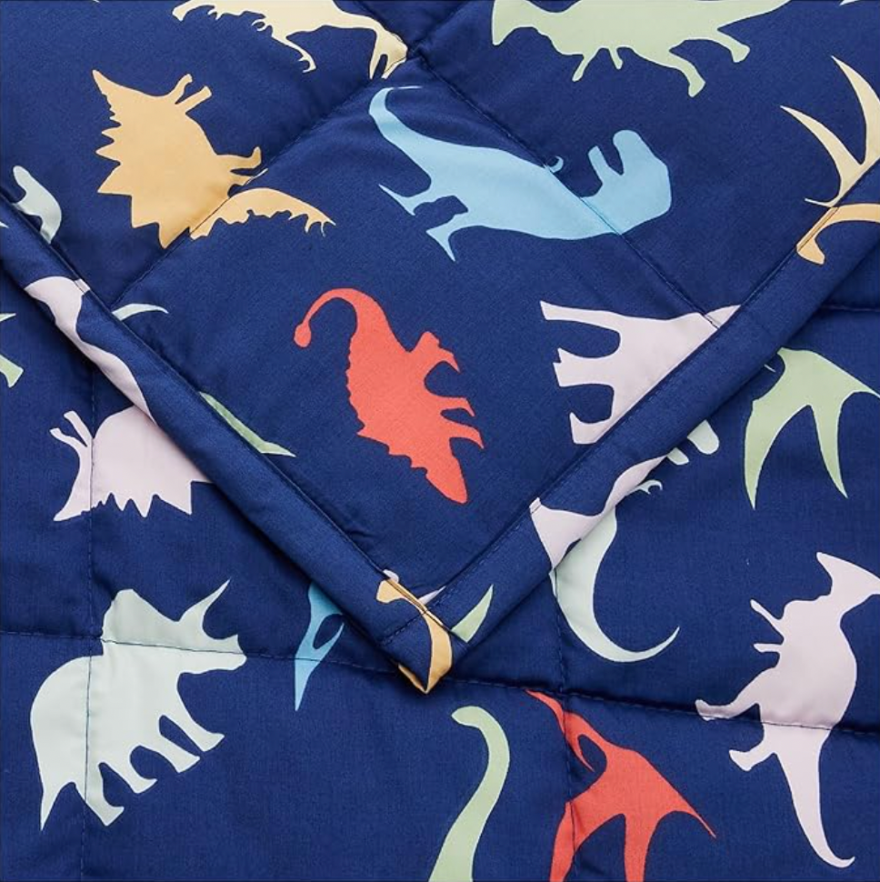 Quilted dinosaur pattern detail on navy weighted blanket with box-stitch texture