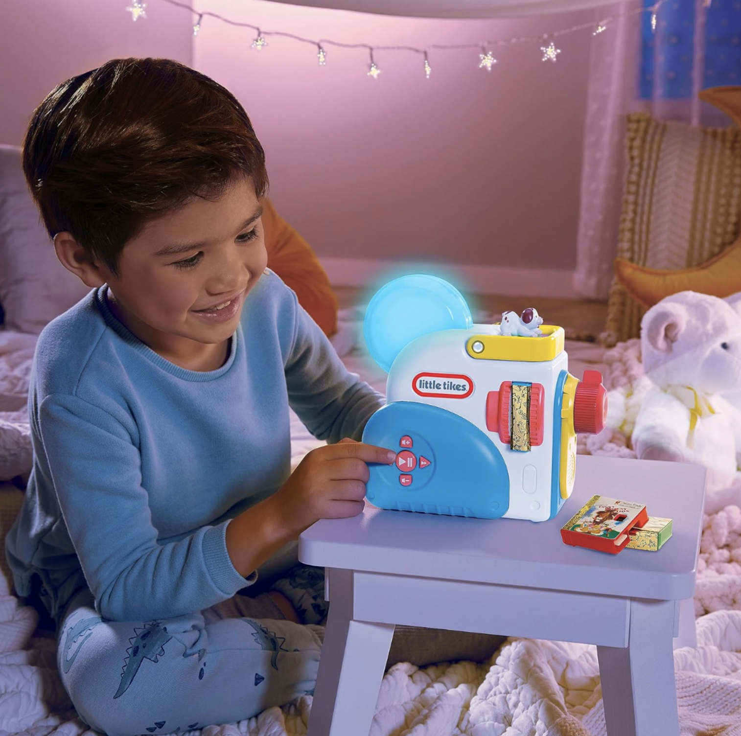 Garçon appuyant sur un bouton du projecteur Little Tikes Story Dream Machine illuminé dans une chambre étoilée