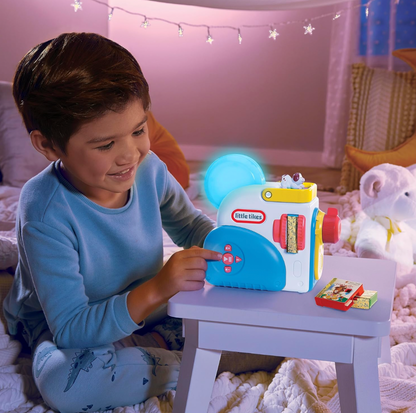 Garçon appuyant sur un bouton du projecteur Little Tikes Story Dream Machine illuminé dans une chambre étoilée