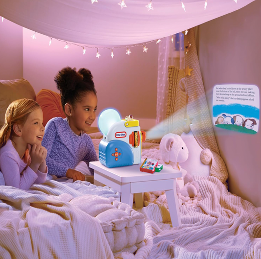 Two girls watching projected story on Little Tikes Story Dream Machine in fairy-light bedroom tent