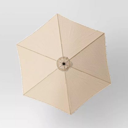 Vue de dessus de la toile hexagonale beige du parasol montrant six panneaux et bordure à franges
