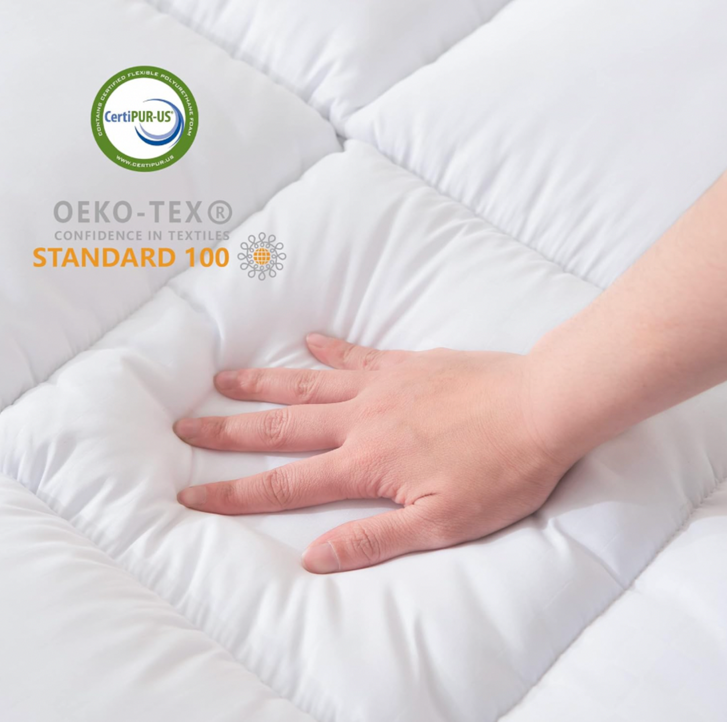 Main pressant le surmatelas matelassé blanc avec badges de certification CertiPUR-US et OEKO-TEX Standard 100