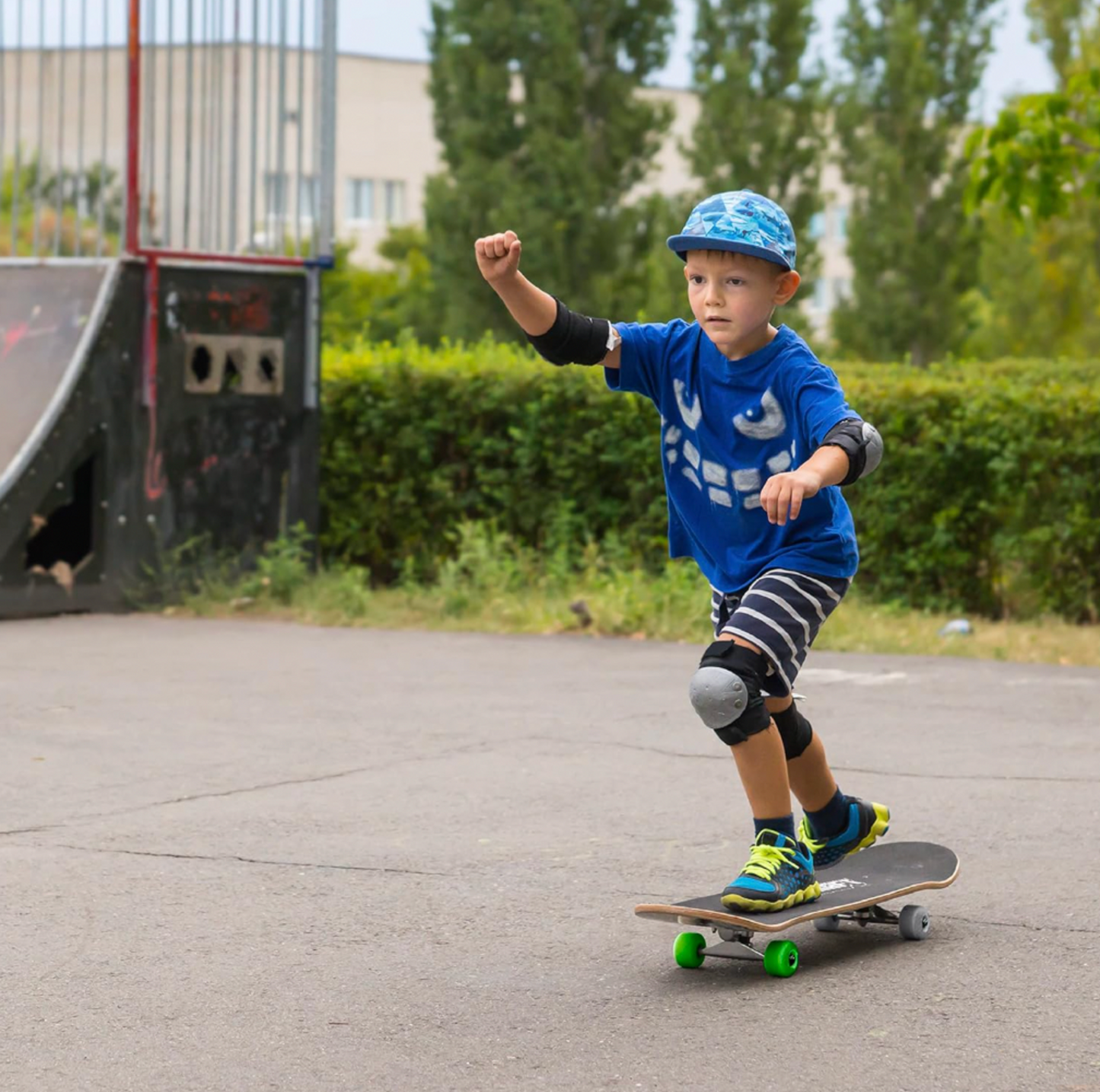 Garçon en chandail bleu et chapeau bob roulant sur une planche à roulettes Minecraft à roues vertes dans un skate parc