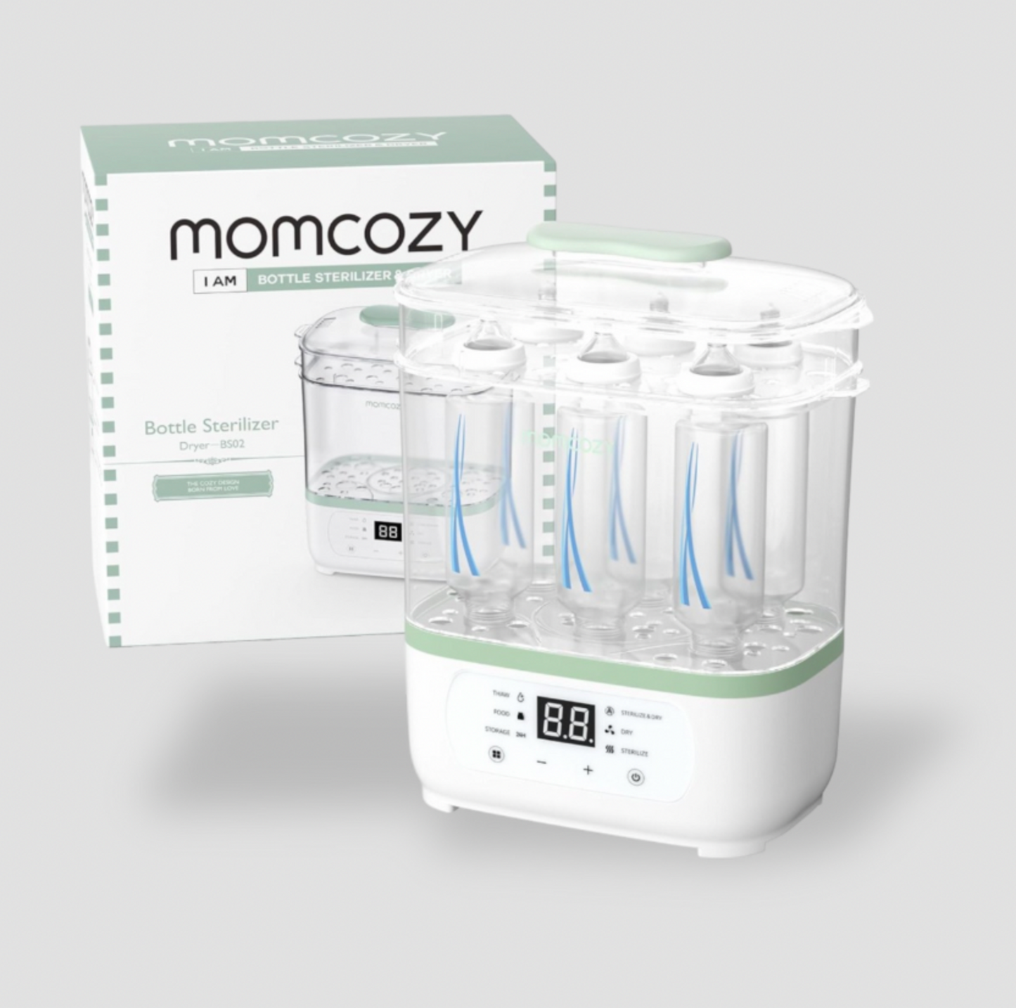 Stérilisateur et séchoir 8-en-1 pour biberons Momcozy en blanc et vert avec biberons chargés à côté de la boîte, vue trois-quarts