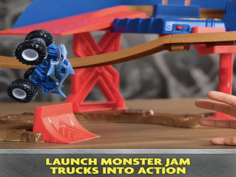 Blue monster truck mid-jump off red ramp on Monster Jam Speedway track with Launch monster jam trucks into action callout