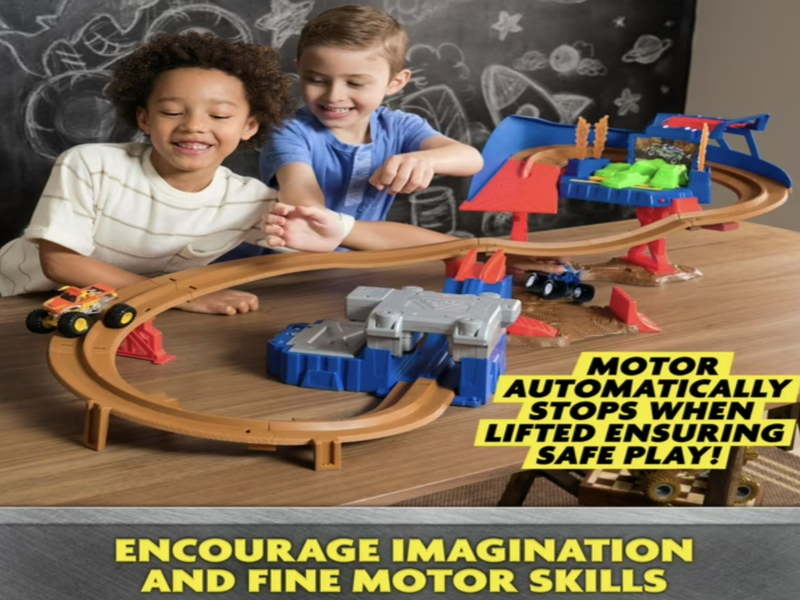 Two boys assembling Monster Jam Speedway track with Motor automatically stops when lifter ensuring safe play callout