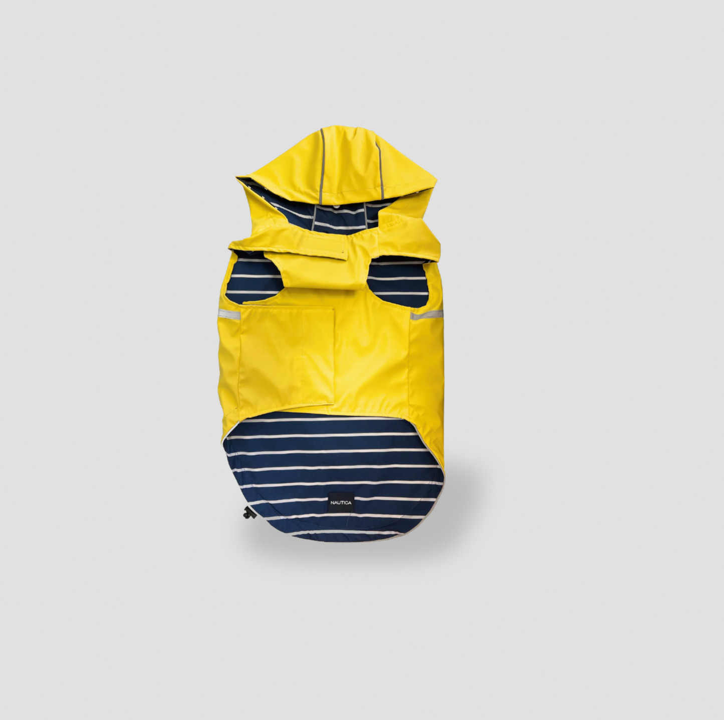 Manteau pour chien Nautica réversible posé à plat montrant la doublure rayée bleu marine et blanc