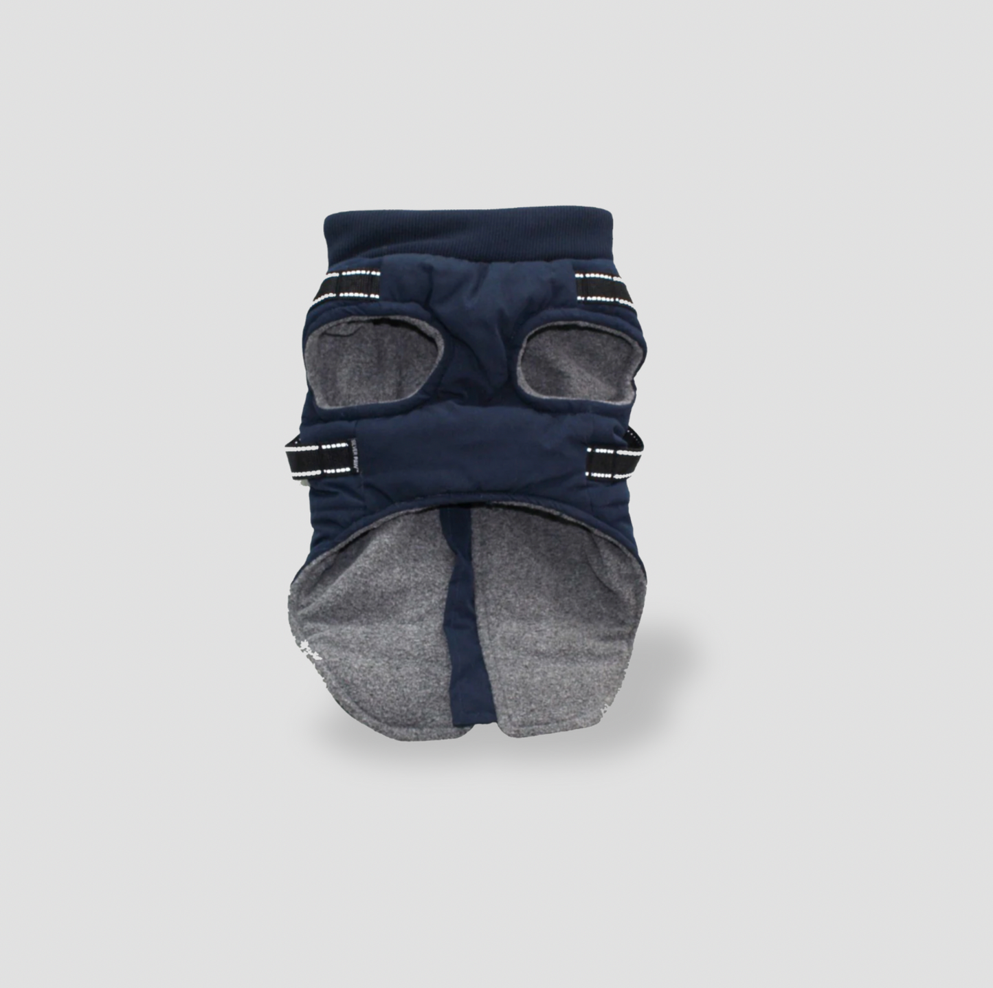 Dessous de la veste pour chien bleu marine montrant la doublure en molleton gris, les ouvertures pour les pattes et les sangles réfléchissantes