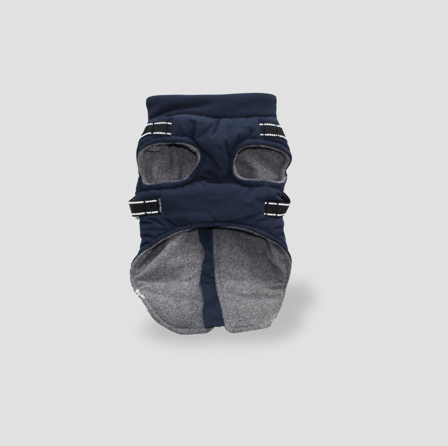 Dessous de la veste pour chien bleu marine montrant la doublure en molleton gris, les ouvertures pour les pattes et les sangles réfléchissantes