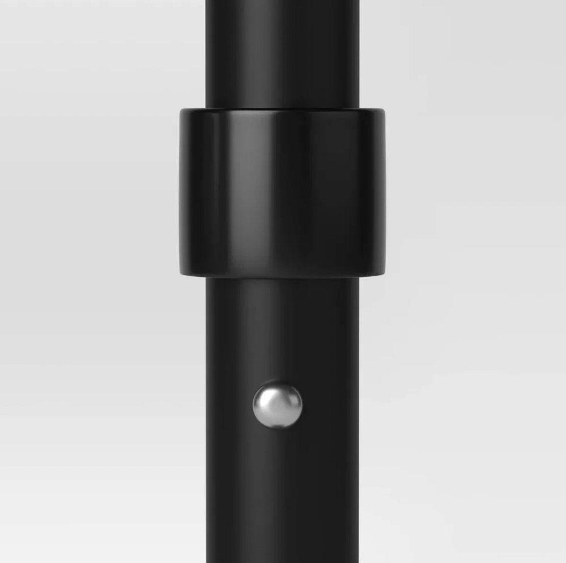 Close-up of black patio umbrella pole with collar joint and silver push-pin lock