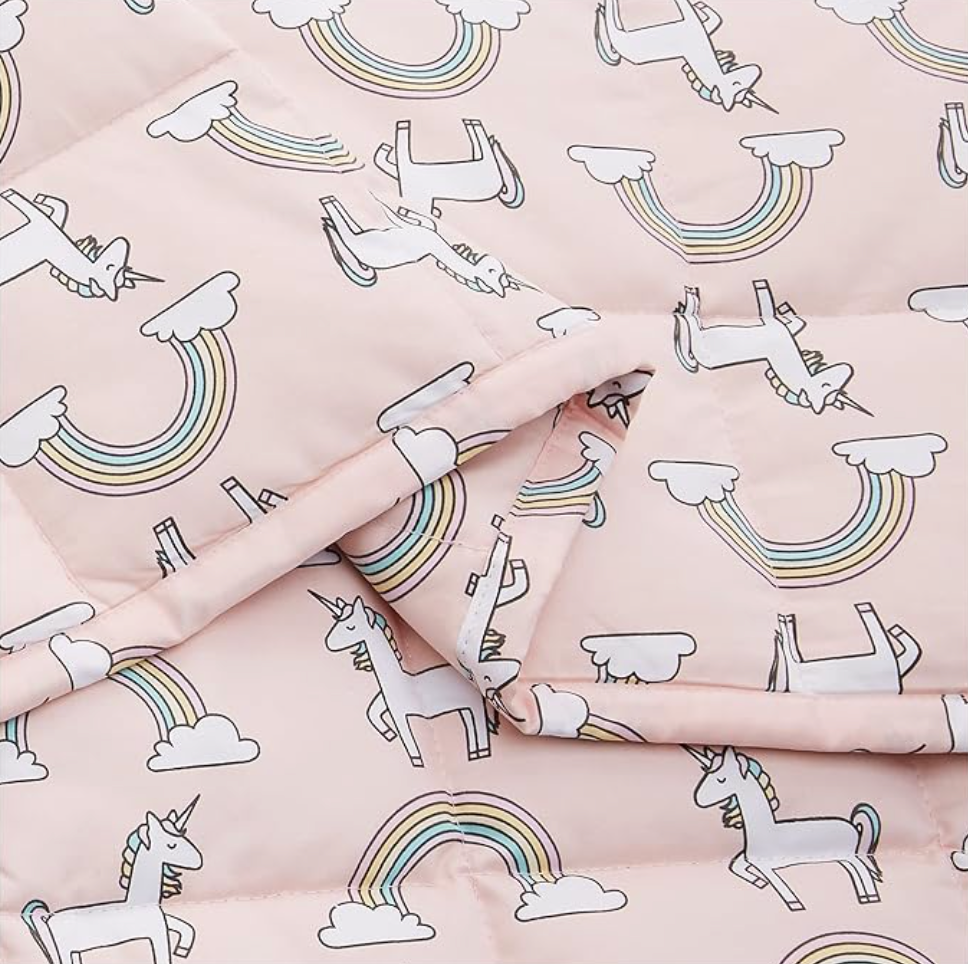 Close-up of pink unicorn and rainbow print cotton blanket with folded layer
