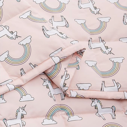 Close-up of pink unicorn and rainbow print cotton blanket with folded layer