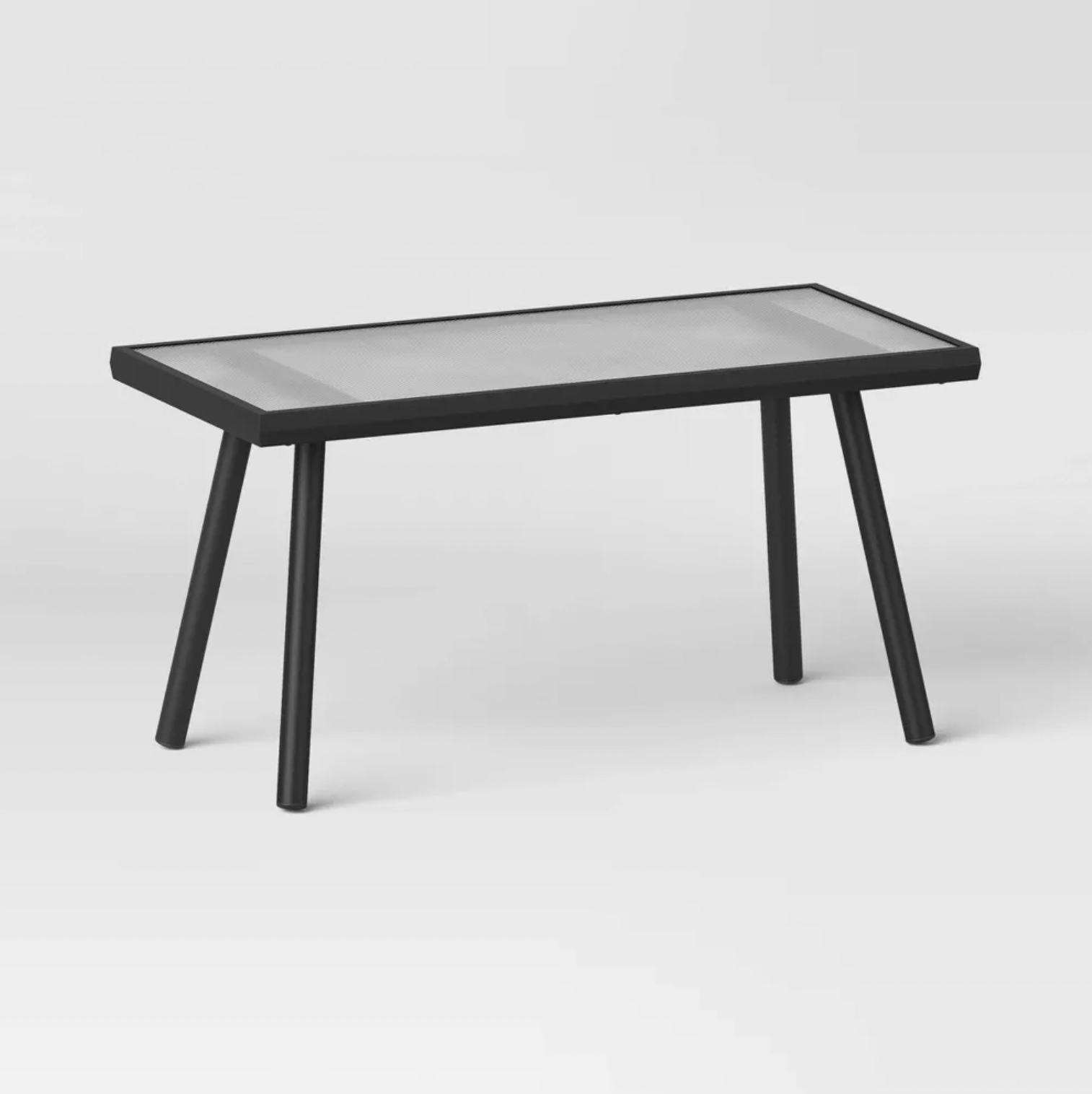 Table basse rectangulaire d'extérieur noire avec plateau en verre texturé et pieds inclinés en acier, vue trois-quarts