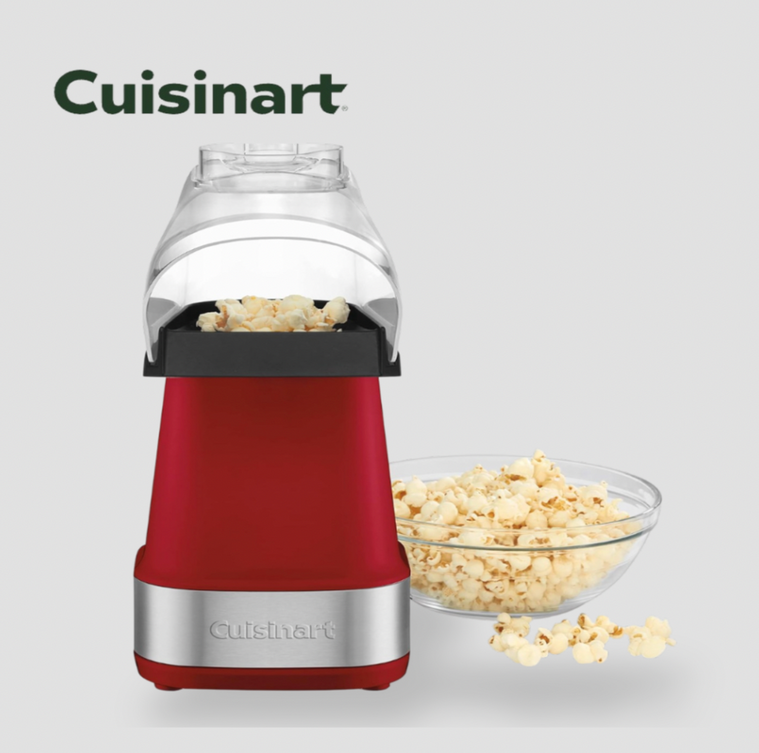Machine à popcorn rouge avec base chromée versant du maïs soufflé frais dans un bol en verre