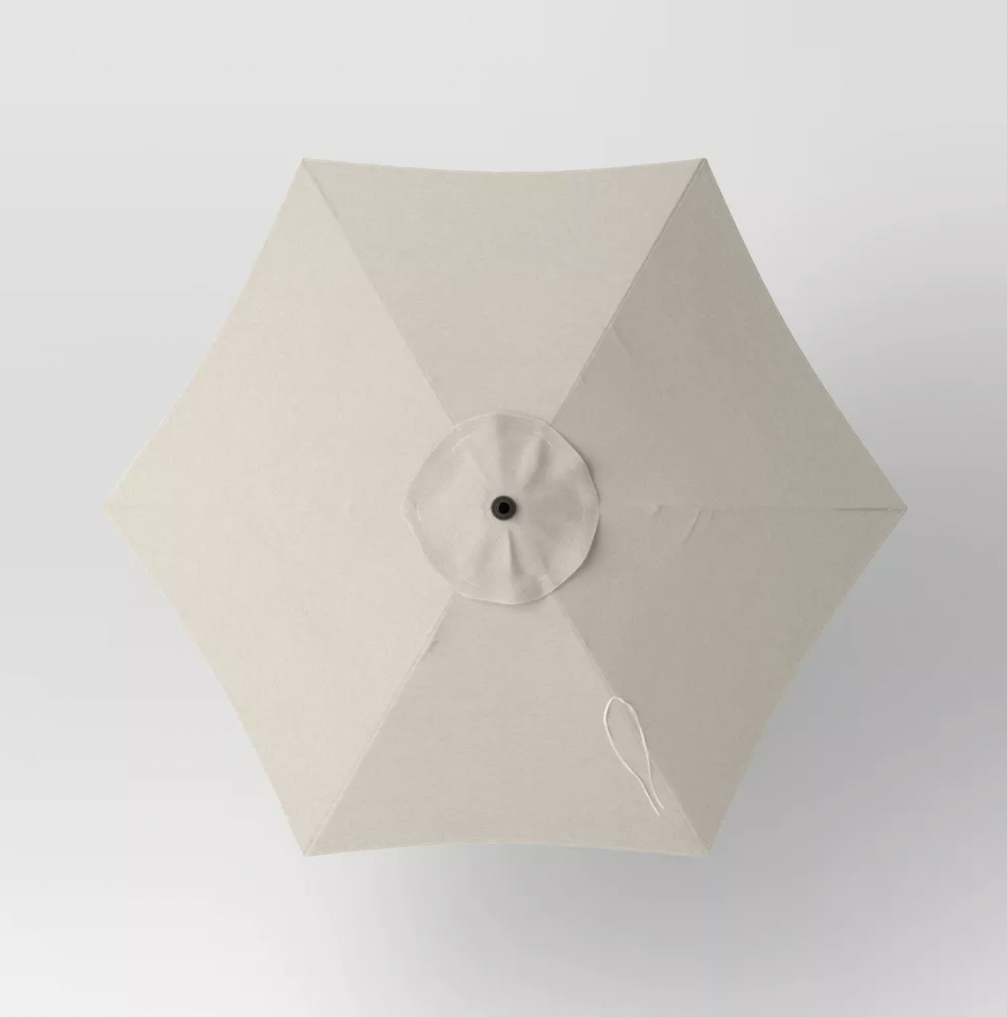 Top-down view of six-panel beige patio umbrella canopy with center vent