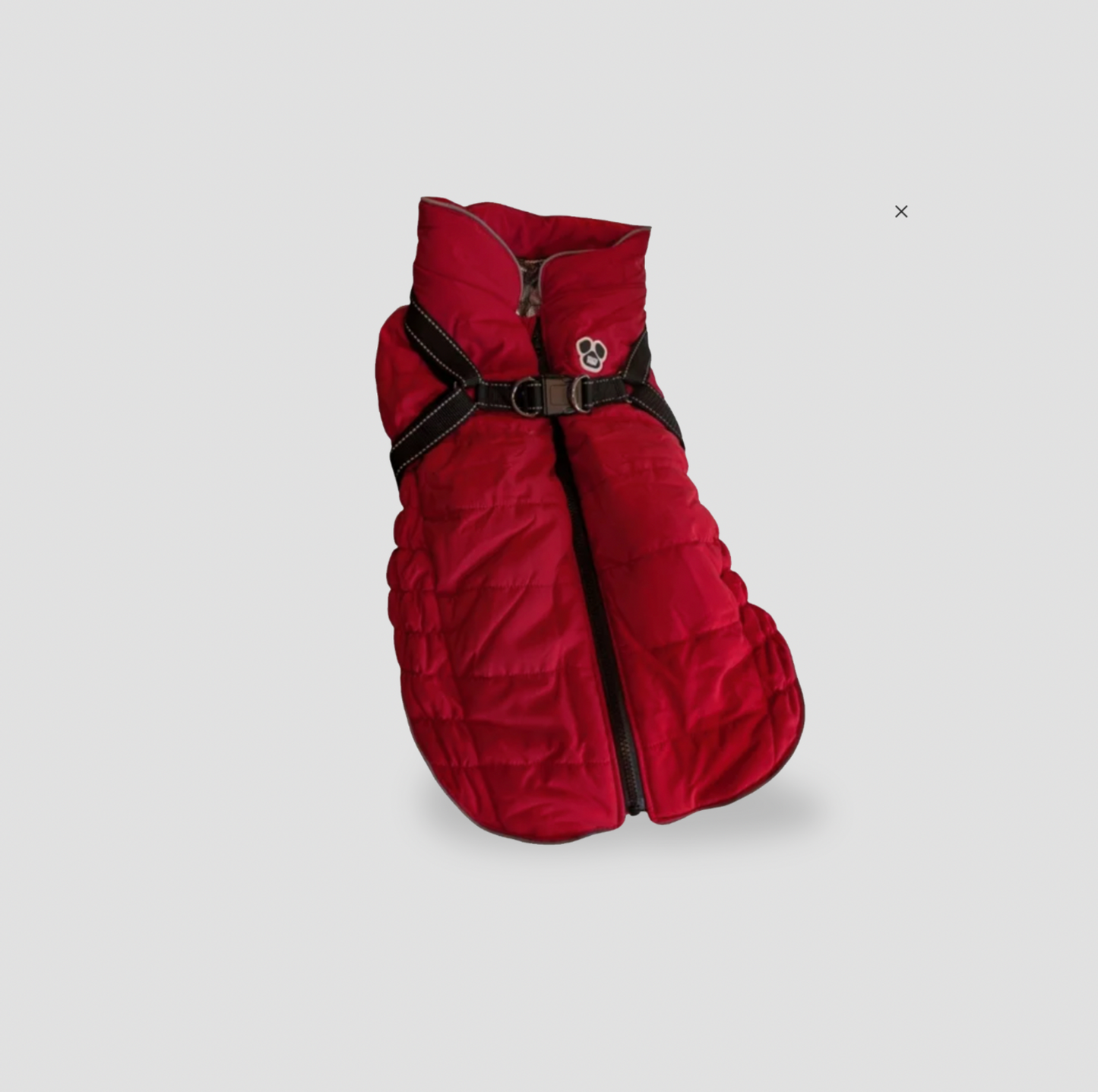 Veste matelassée rouge pour chien avec sangles de harnais noires intégrées et logo patte, vue trois-quarts
