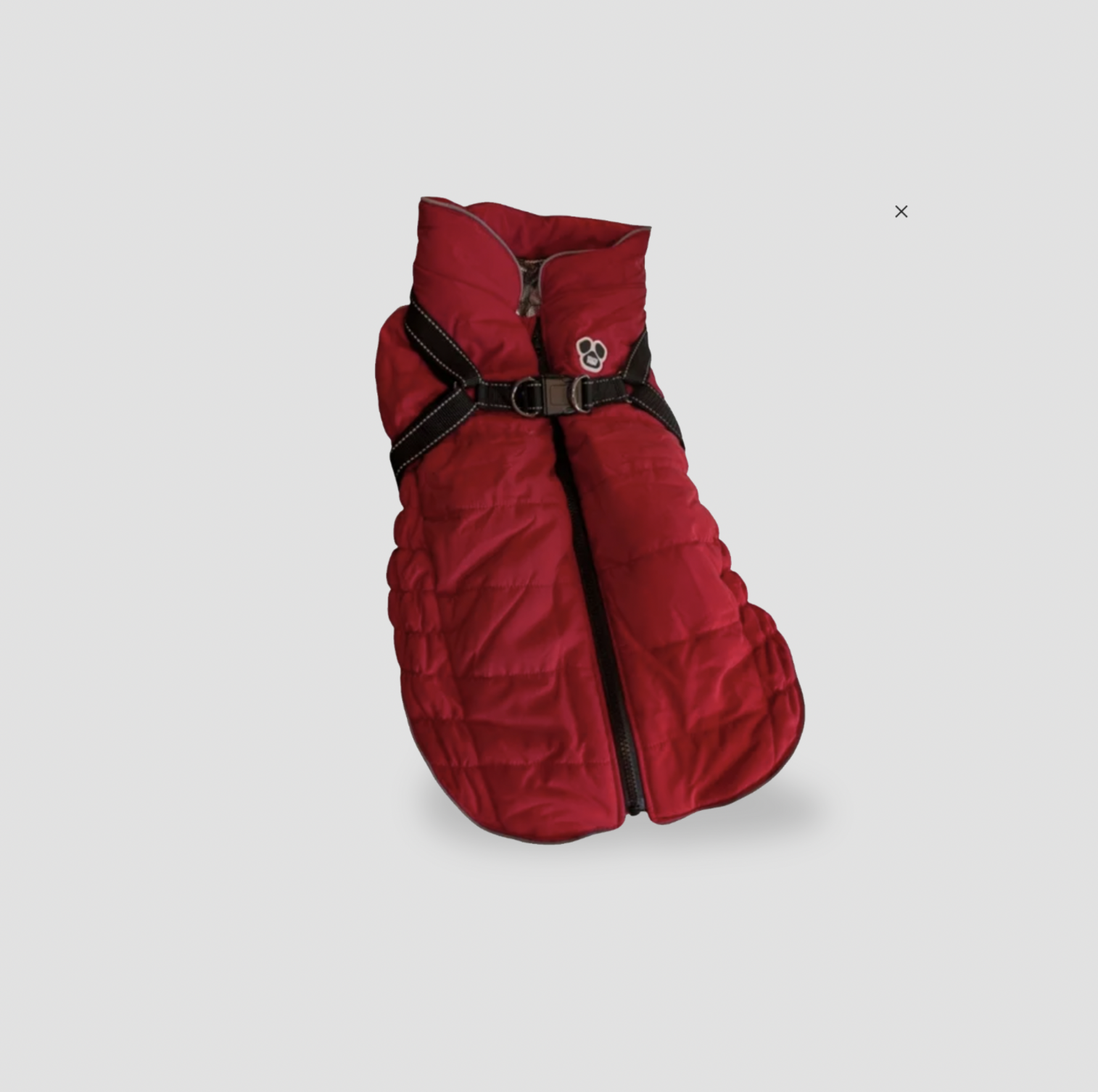 Veste matelassée rouge pour chien avec sangles de harnais noires intégrées et logo patte, vue trois-quarts