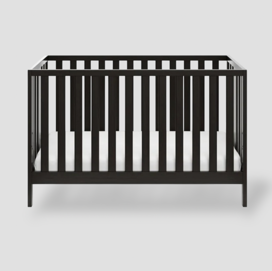 Black Storkcraft Pacific 4-in-1 convertible crib with slatted sides and white mattress, front view