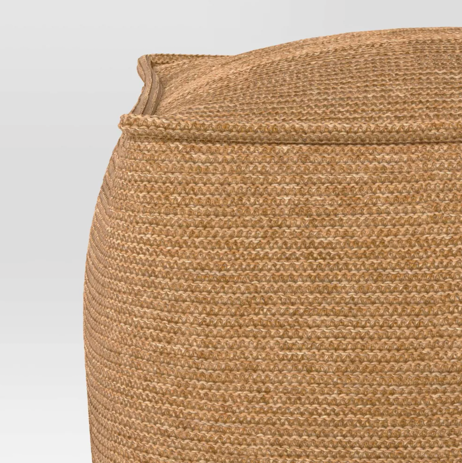 Gros plan de la texture en tissu tricoté tan tissé sur le coin du pouf de patio