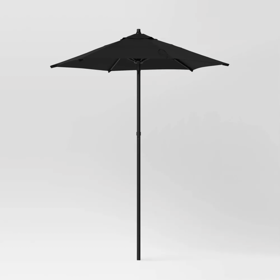 Parasol de patio noir pleine longueur avec mât en métal noir sur fond blanc