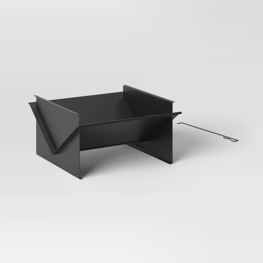 Black steel flat-pack outdoor fire pit with V-shaped panels and metal poker, three-quarter view