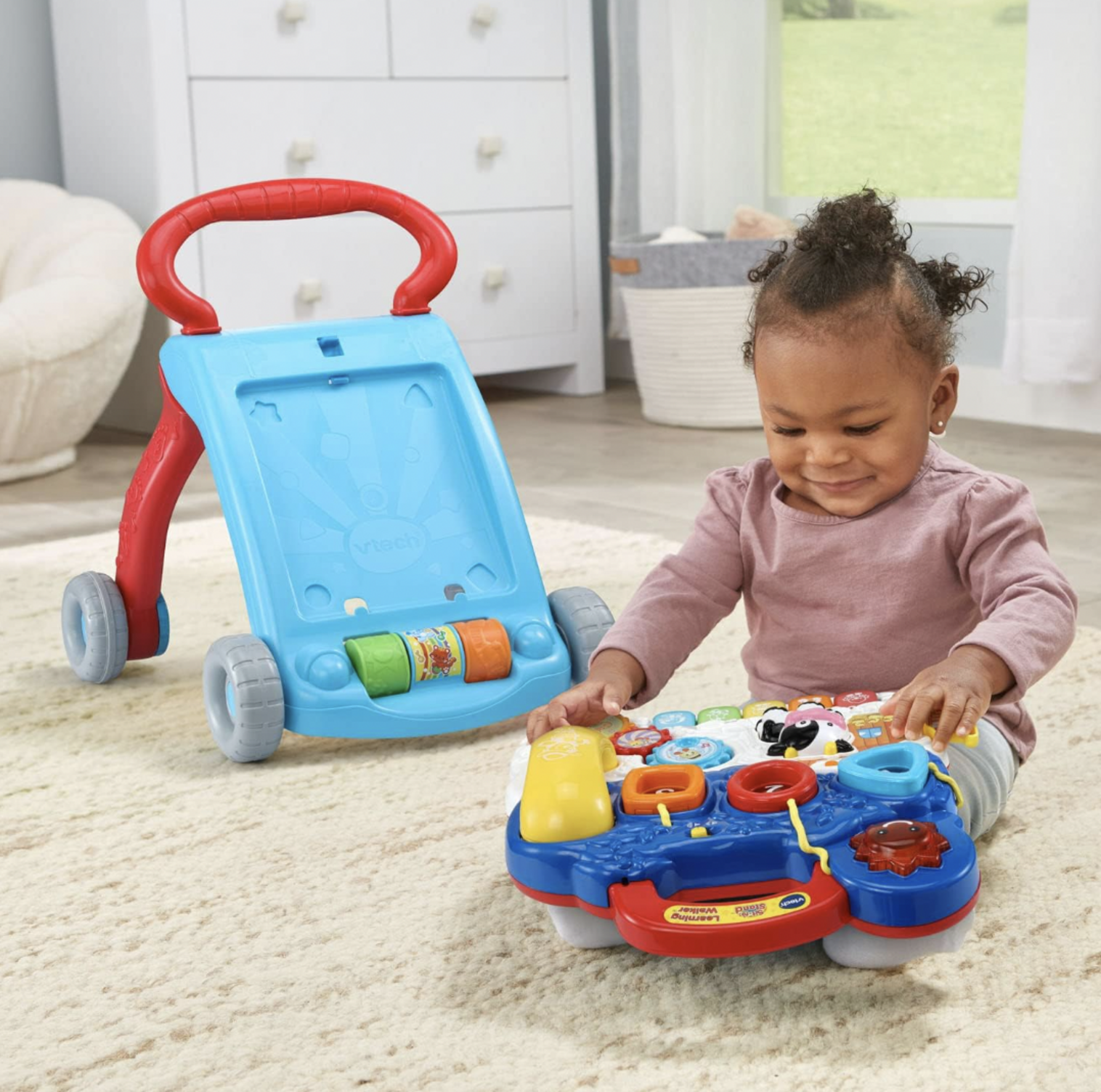 Jeune fille jouant avec le panneau d'activités détachable du trotteur VTech sur le tapis du salon